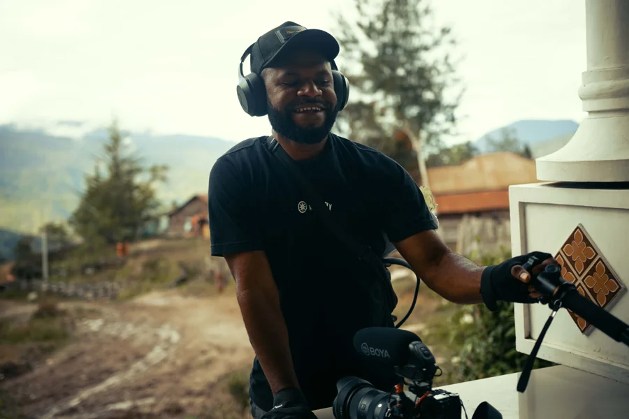 Vidéaste avec casque audio et caméra lors d'un tournage en extérieur
